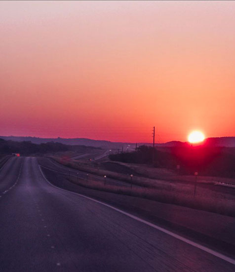 photo of highway with sun setting in the West